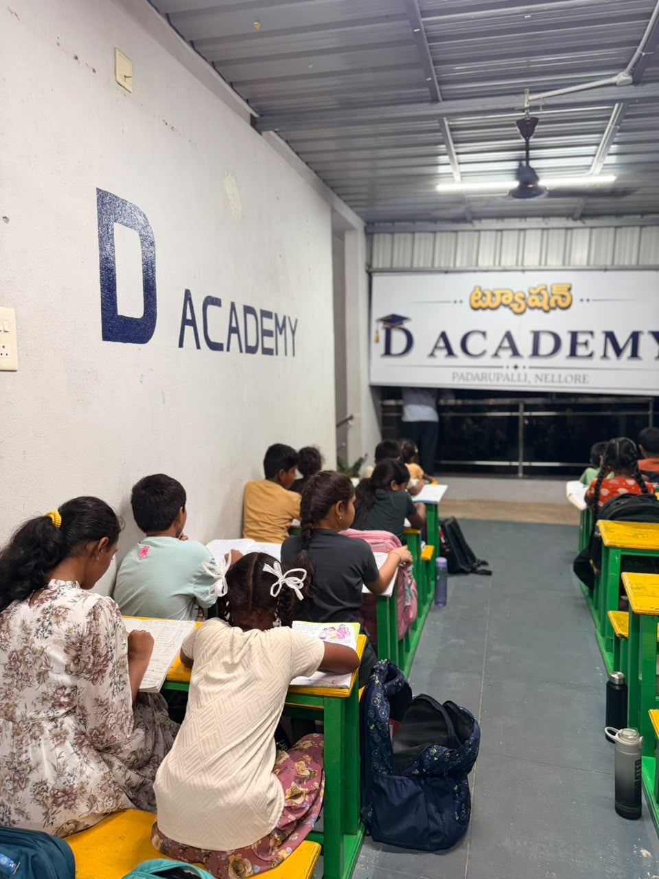 An evening class in progress at D Academy, students seated facing the board