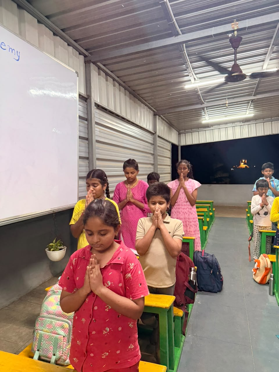 D Academy students standing for the daily prayer before class
