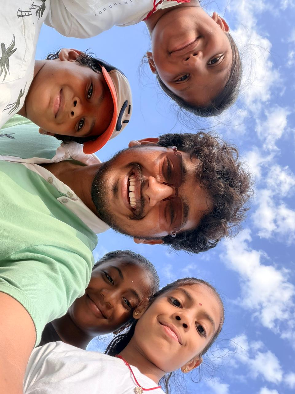 D Academy students and their teacher outdoors under a bright sky